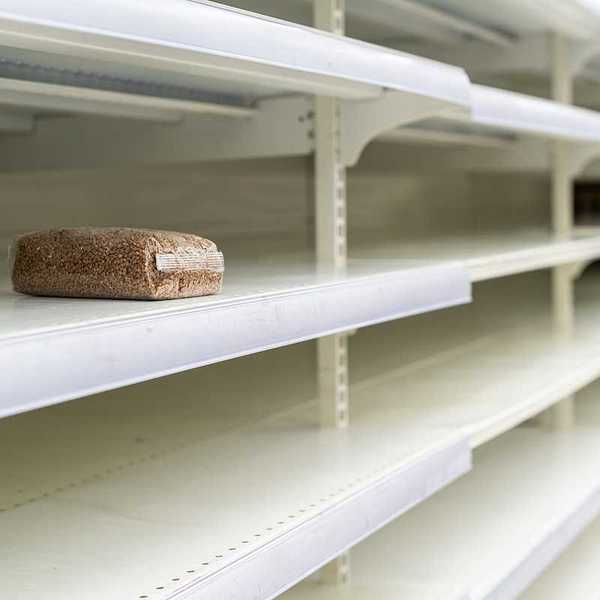 A lone package of grain on otherwise empty supermarket shelves
