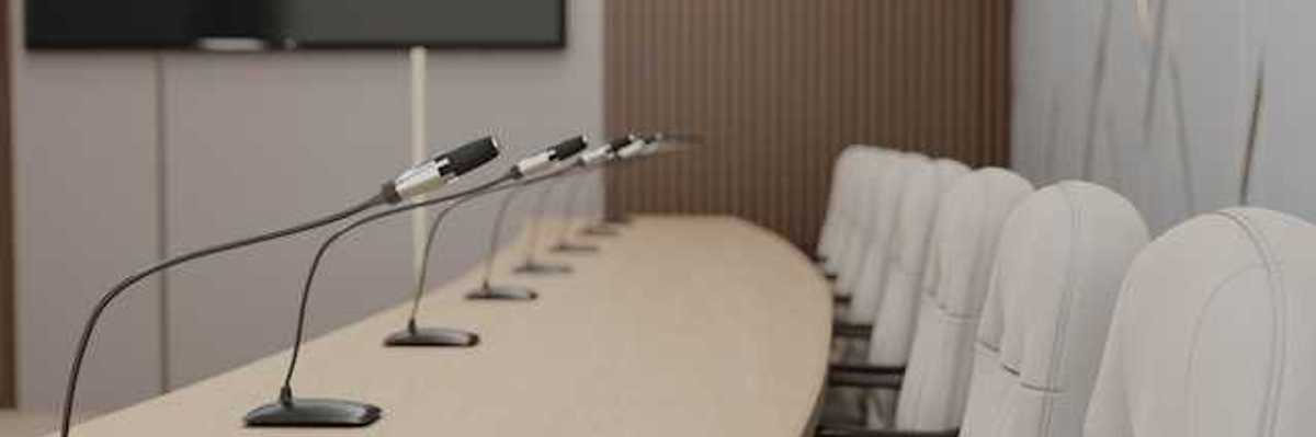 A long table with microphones at each seat