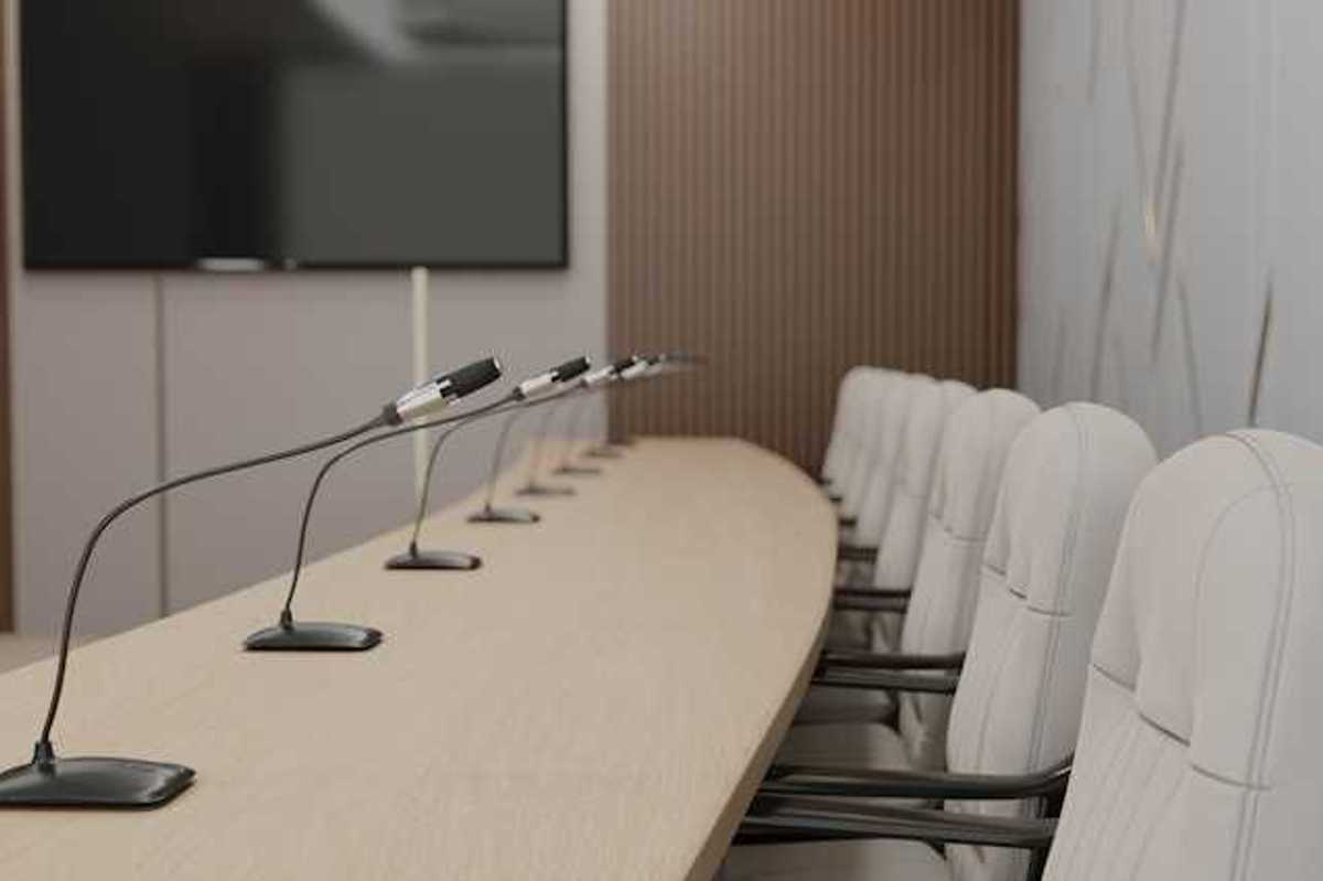 A long table with microphones at each seat