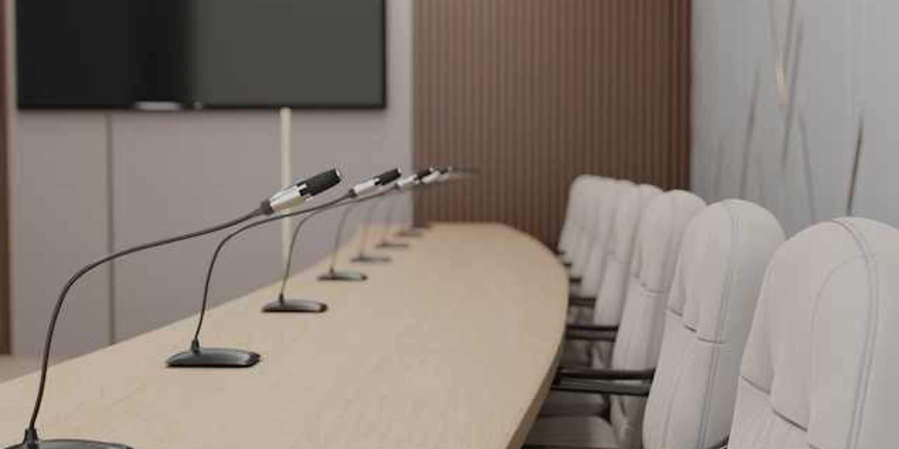A long table with microphones at each seat