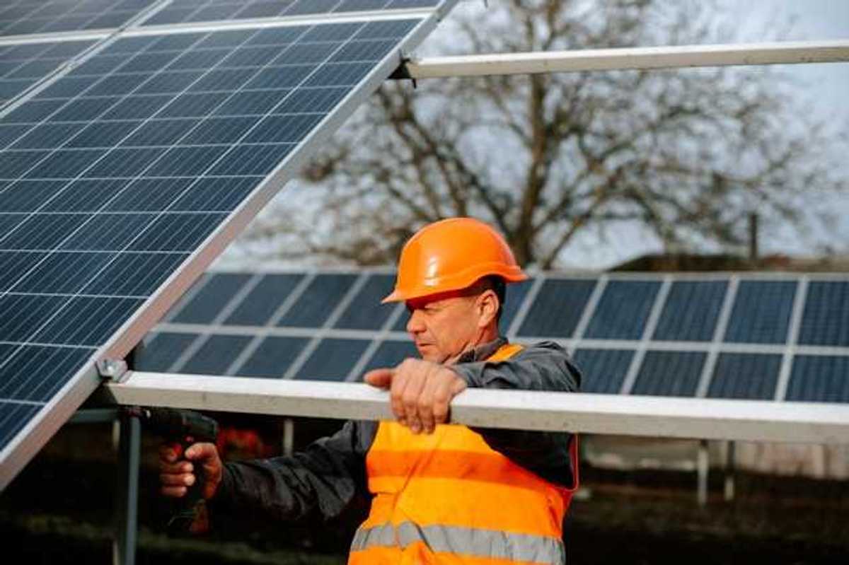 A maintenance worker installing solar panels