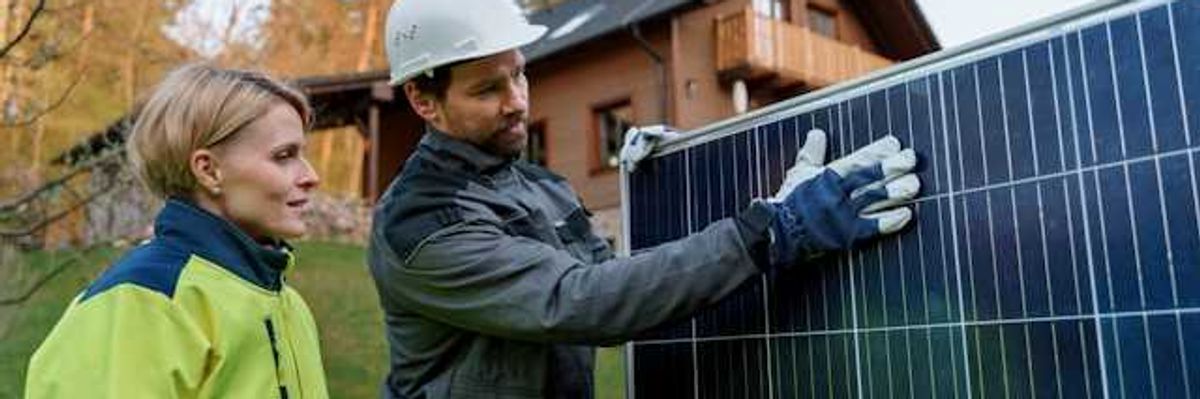 A man and woman inspecting a solar panel