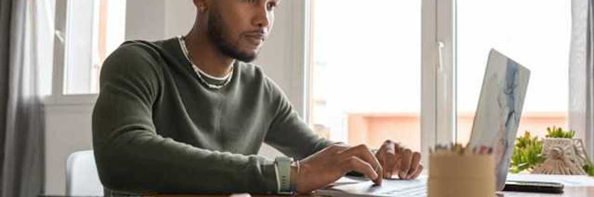 A man at a table working on a computer
