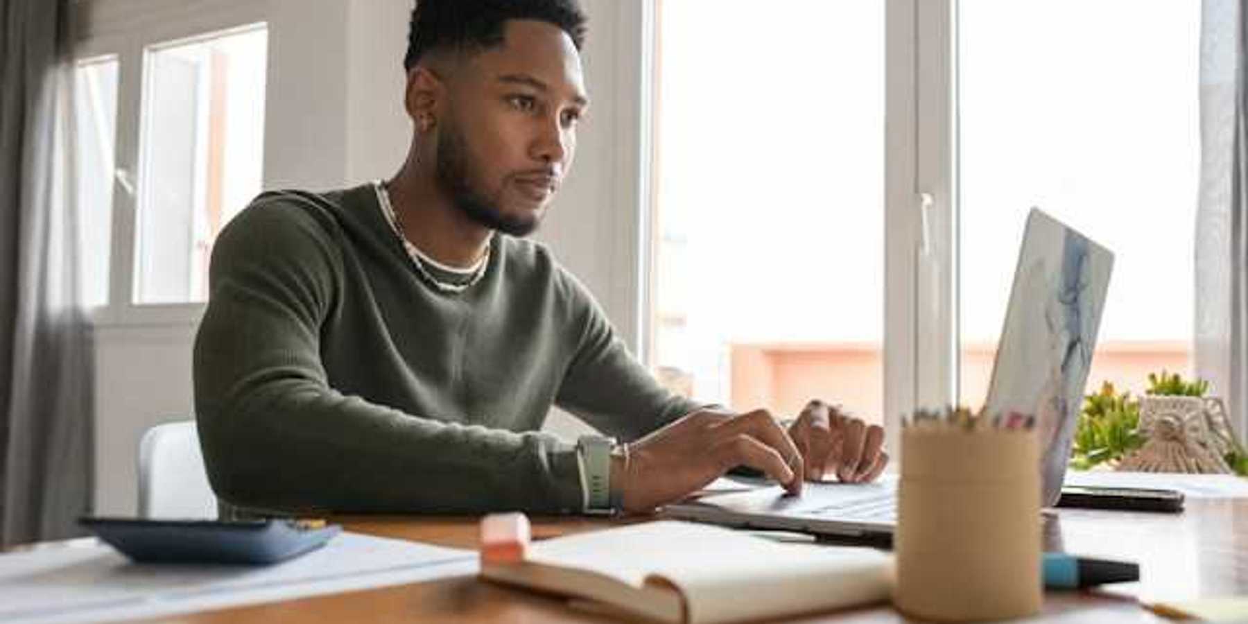 A man at a table working on a computer