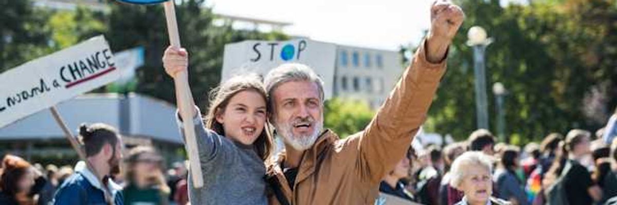 A man holding his daughter during a climate protest