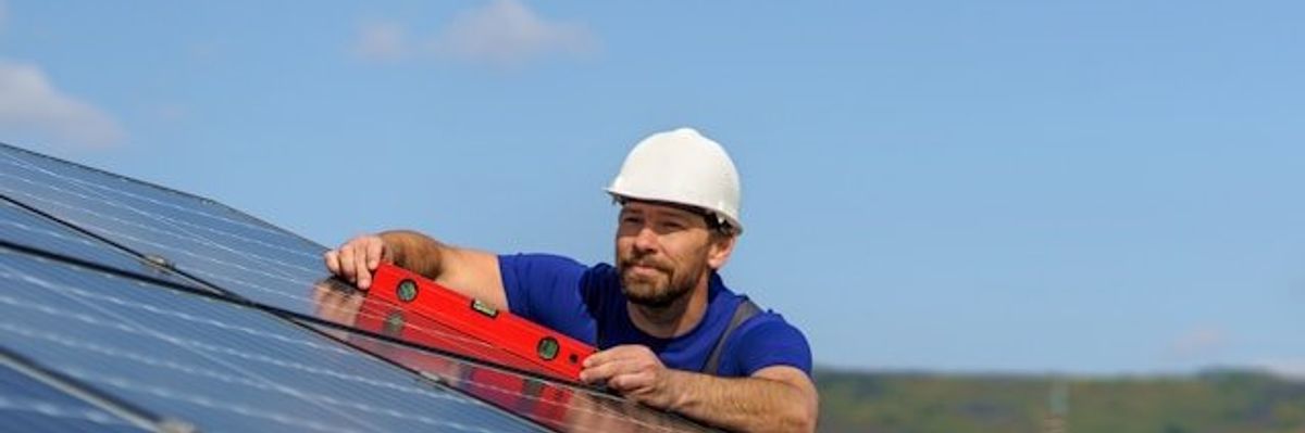 A man installing a solar panel on a roof.