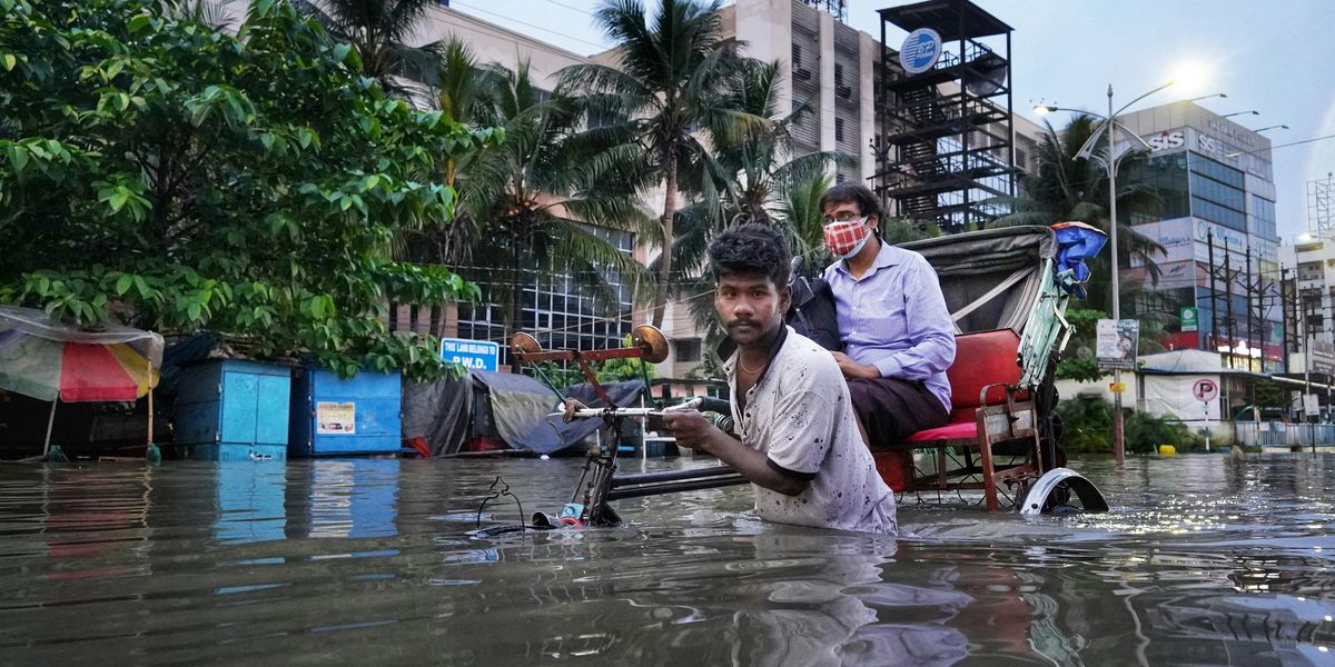 A man pulling a rickshaw in a flooded street.