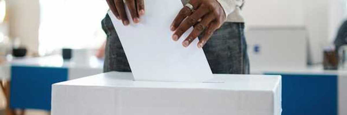 A man putting his vote in a ballot box in the U.S.