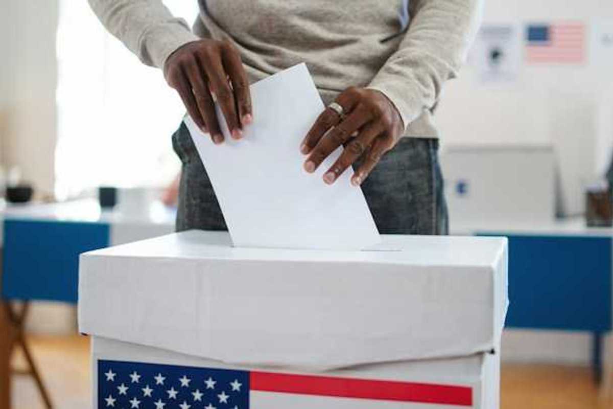 A man putting his vote in a ballot box in the U.S.