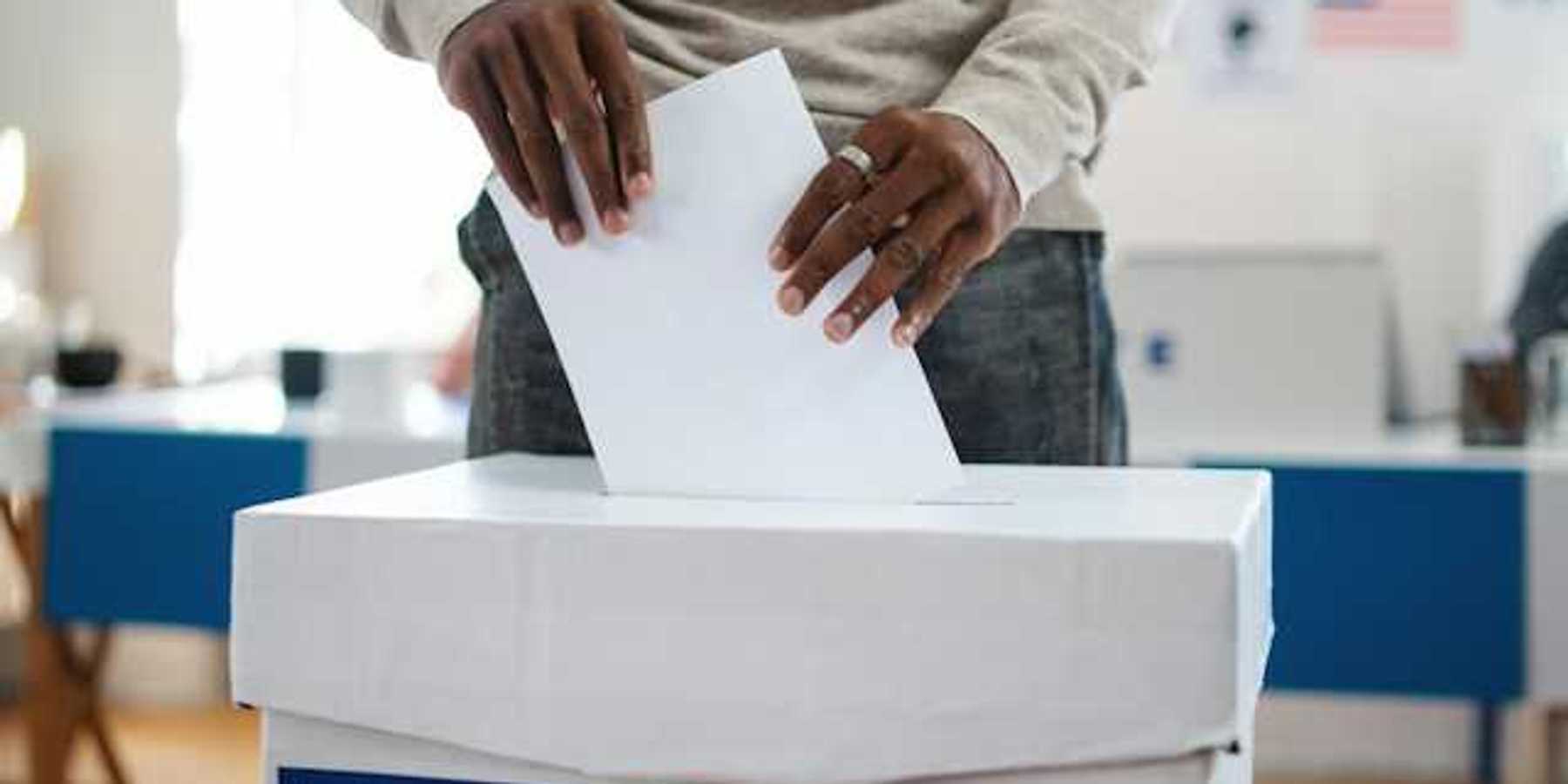 A man putting his vote in a ballot box in the U.S.