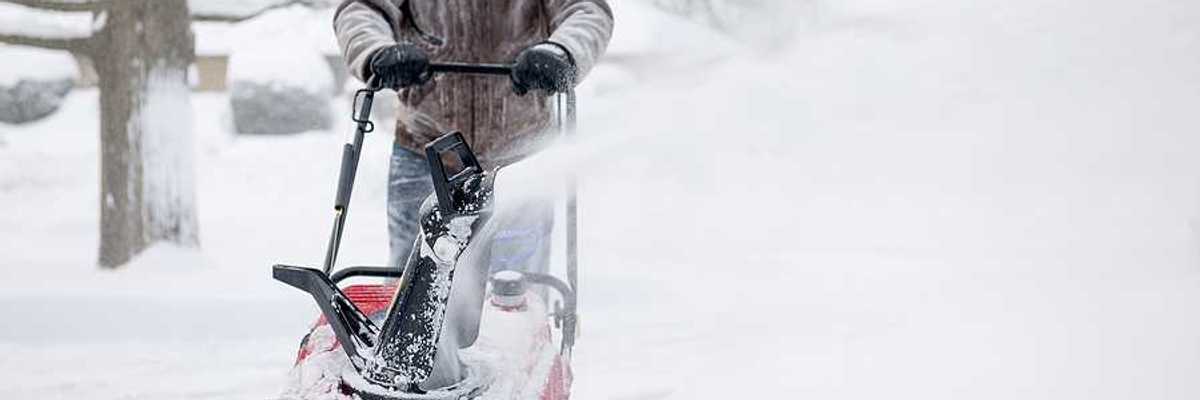 A man using a snow blower on a snowy day