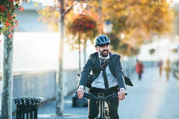 A man wearing a business suit riding his bike to work