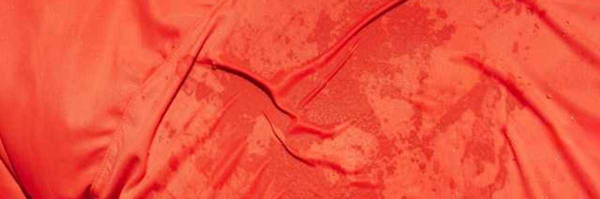 A man wearing a red shirt that appears to be wet