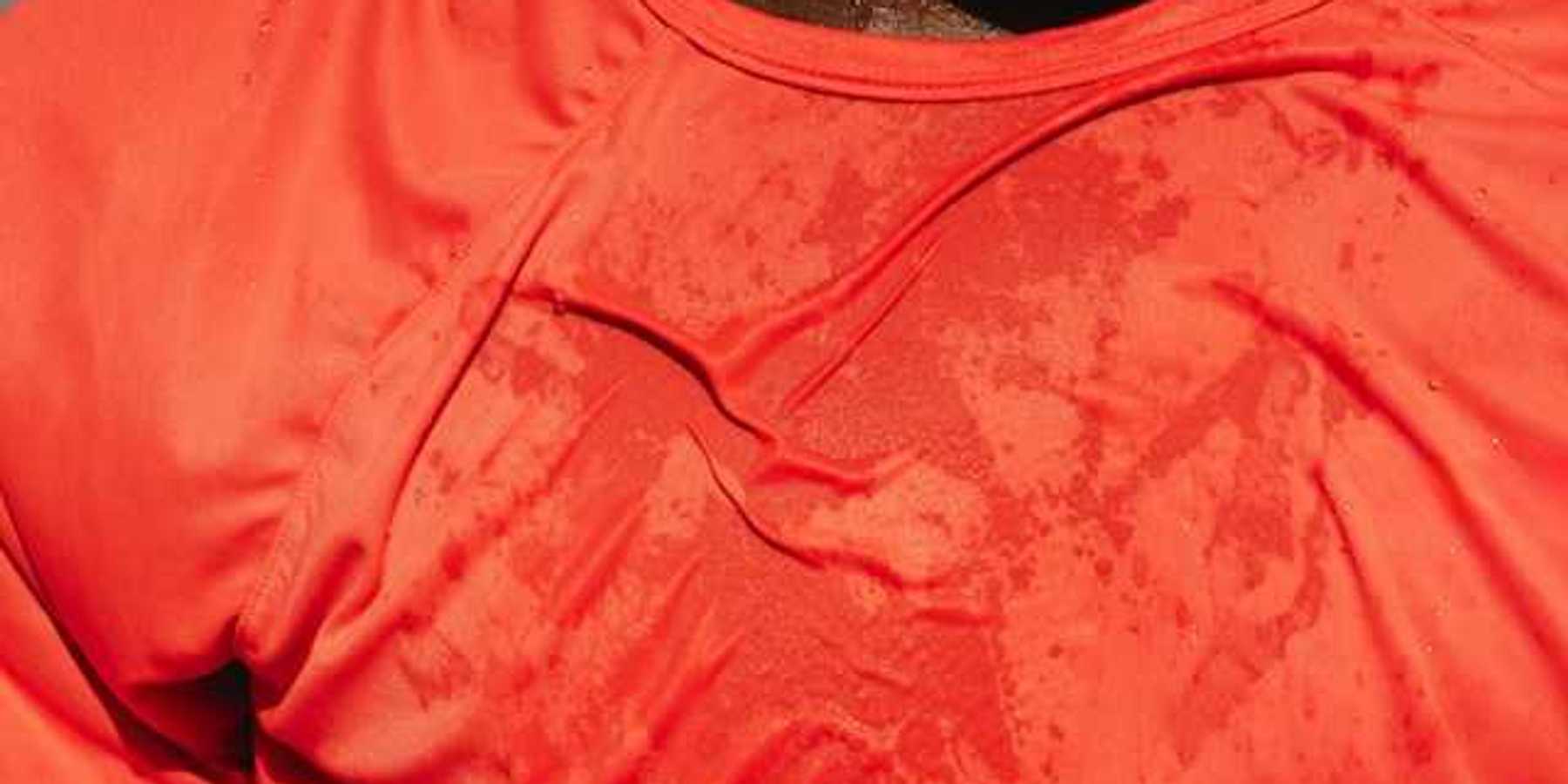 A man wearing a red shirt that appears to be wet