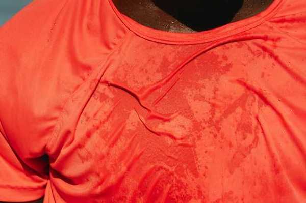 A man wearing a red shirt that appears to be wet