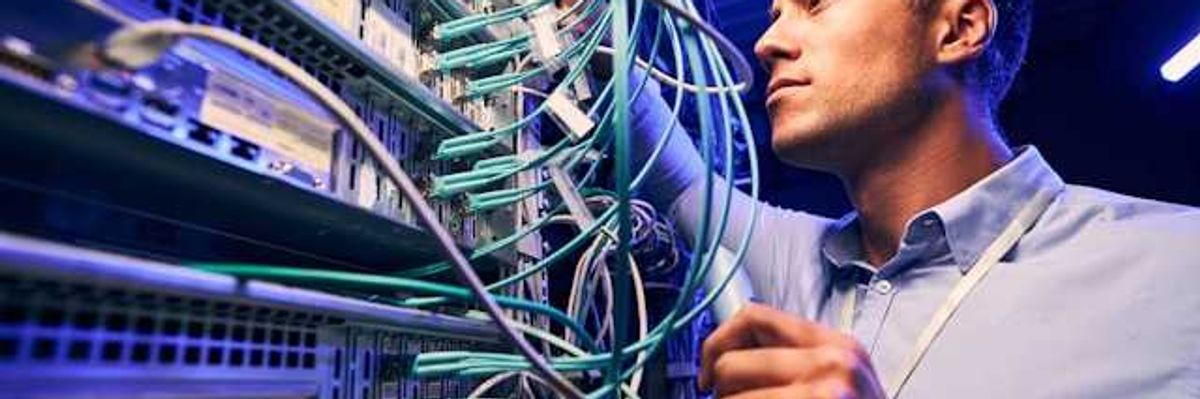 A man working on wires on a data server