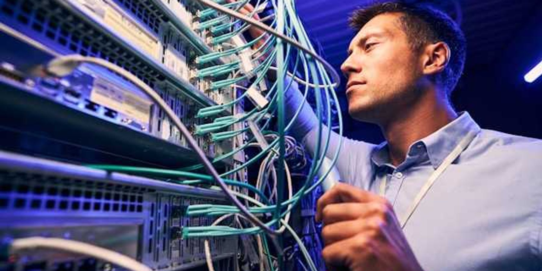A man working on wires on a data server