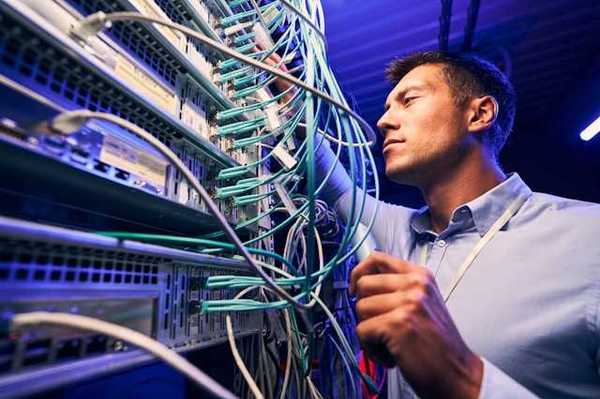 A man working on wires on a data server