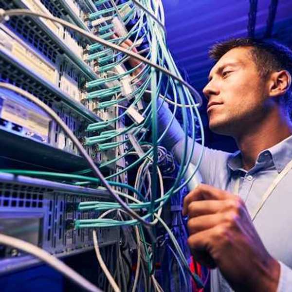 A man working on wires on a data server