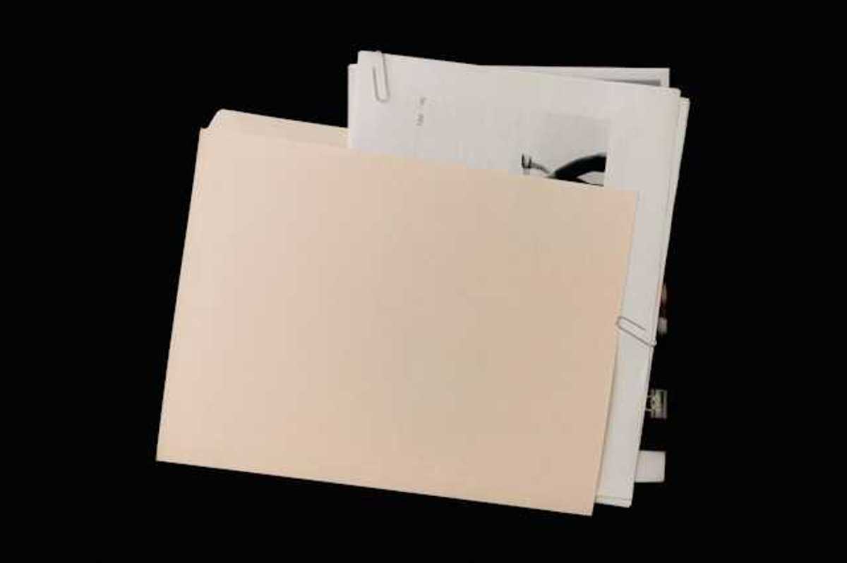 A manila folder covering a pile of documents