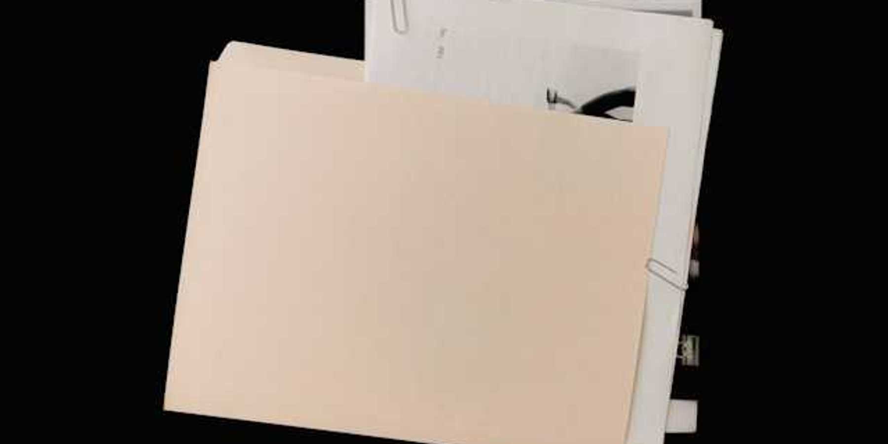 A manila folder covering a pile of documents