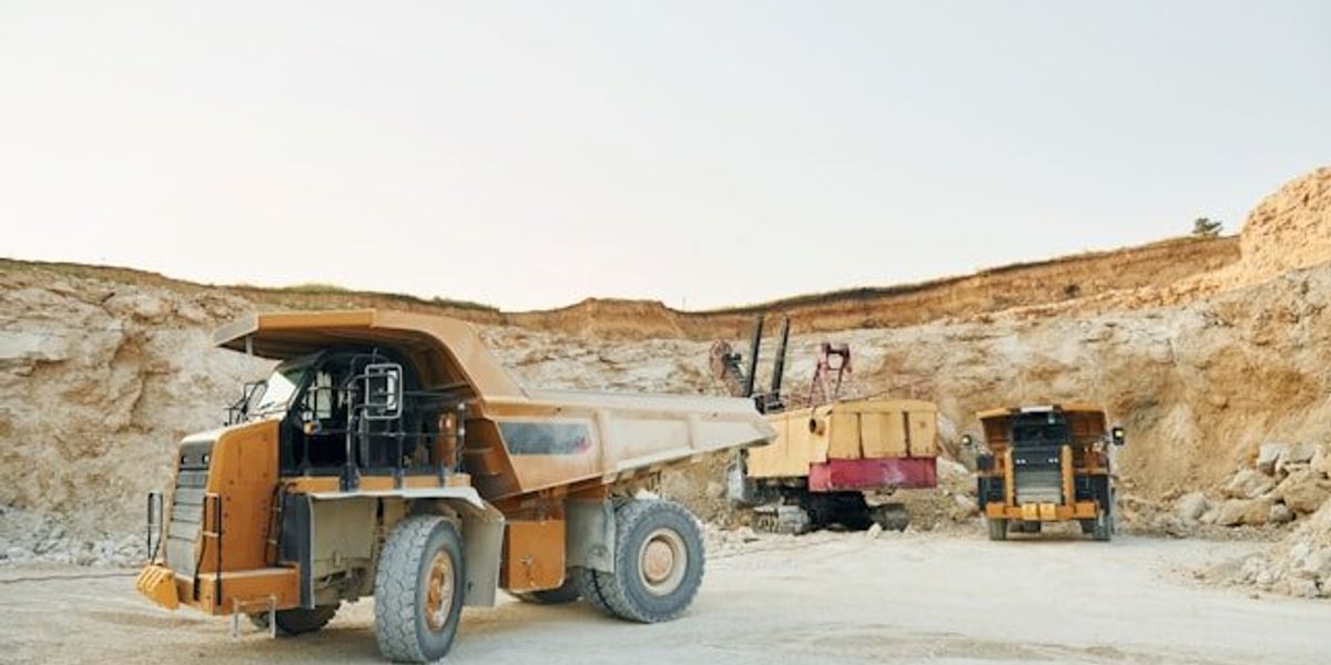 A mine pit with yellow mining trucks.
