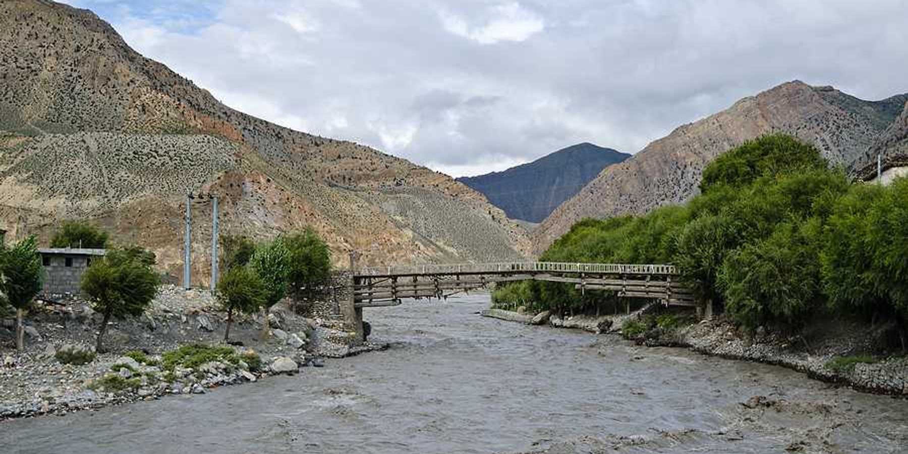 A muddy rising river in a valley in Nepal