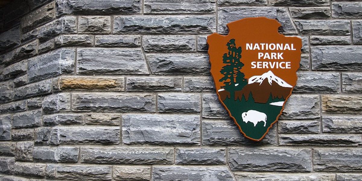 A National Park Service sign on the side of a brick building.