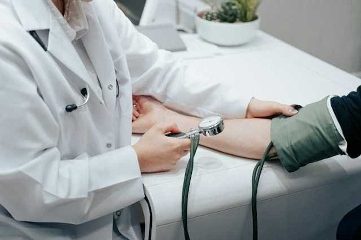 A nurse holding a blood pressure gauge while taking a patient's blood pressure