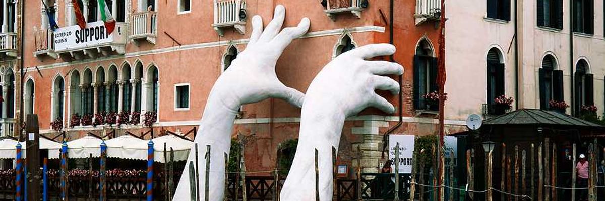 A pair of giant hands rising out of a Venice canal to hold up a building