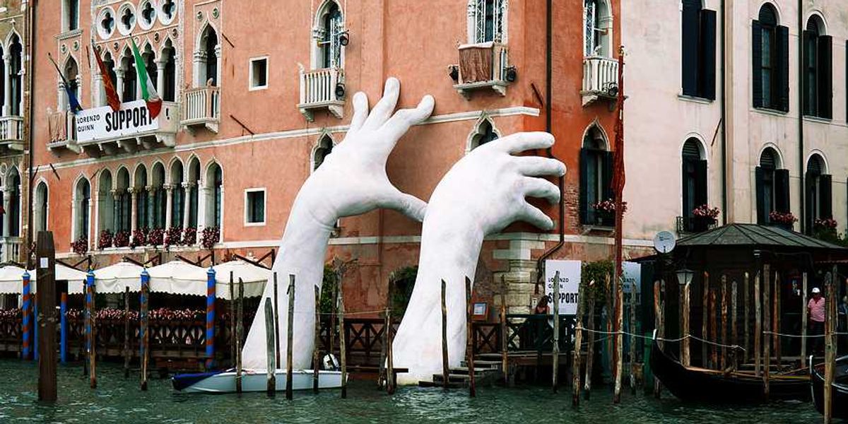 A pair of giant hands rising out of a Venice canal to hold up a building