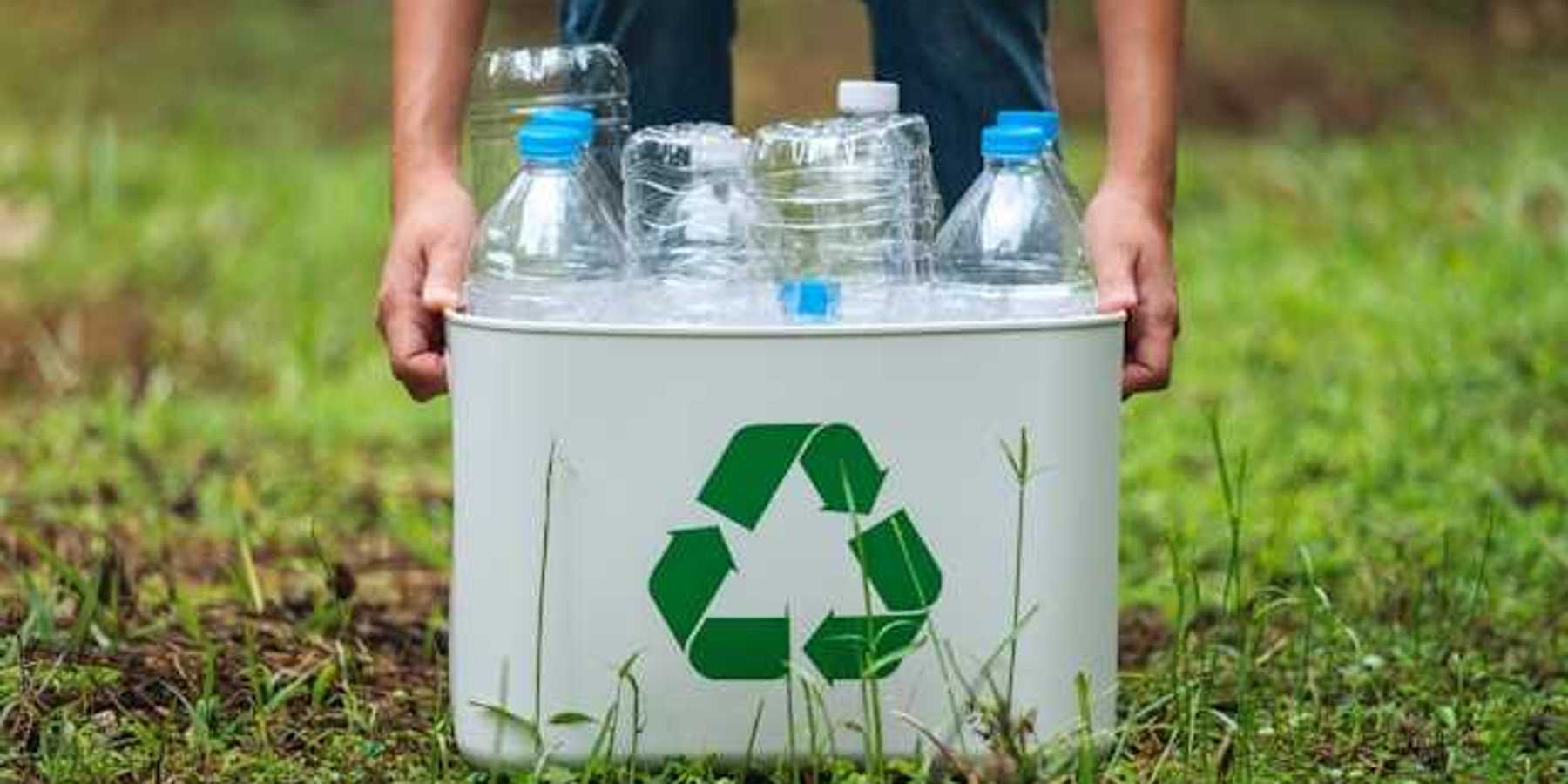 A person collecting plastic bottles in a recycling container