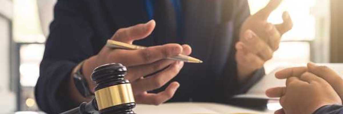 A person gesturing at another person with a court gavel in front of them