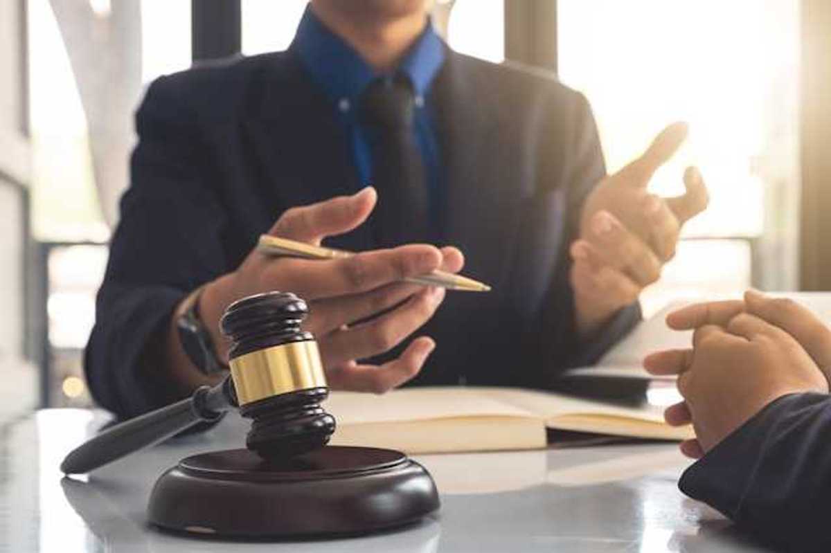 A person gesturing at another person with a court gavel in front of them