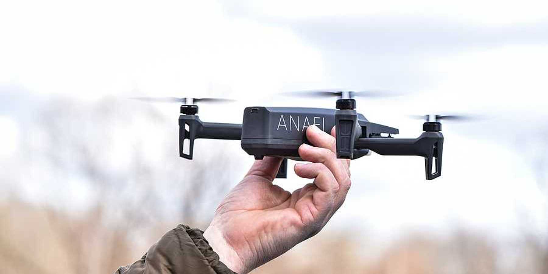 A person holding a drone aloft