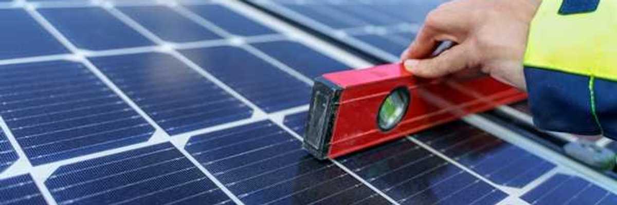 A person holding a level on a solar panel
