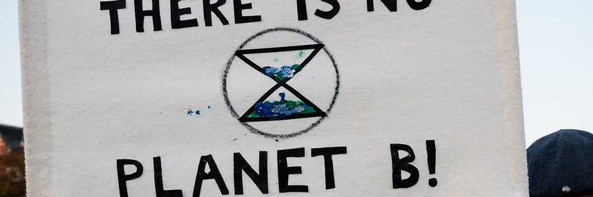 A person holding a sign at a protest saying There is no planet b!