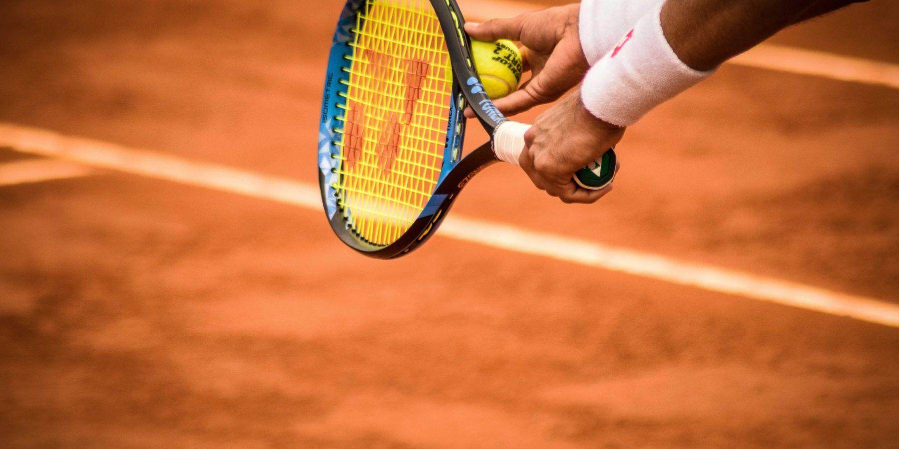 a person holding a tennis racket on a tennis court