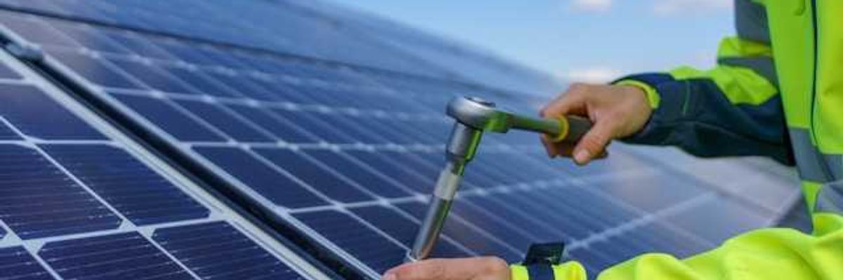 A person installing solar panels on a rooftop