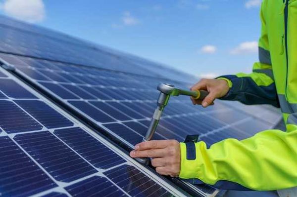 A person installing solar panels on a rooftop