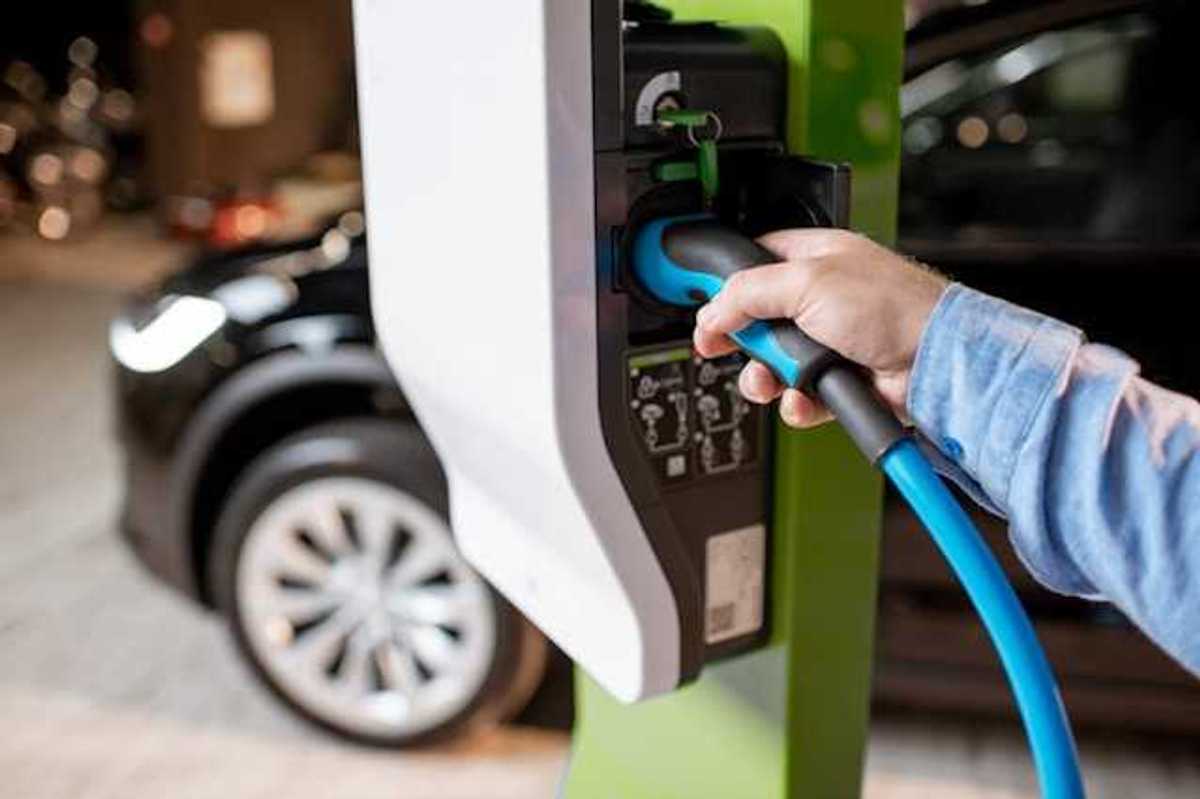 A person plugging an EV into a car charger