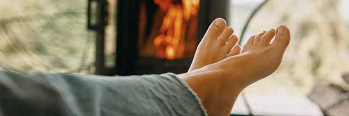 A person sitting in front of a woodstove