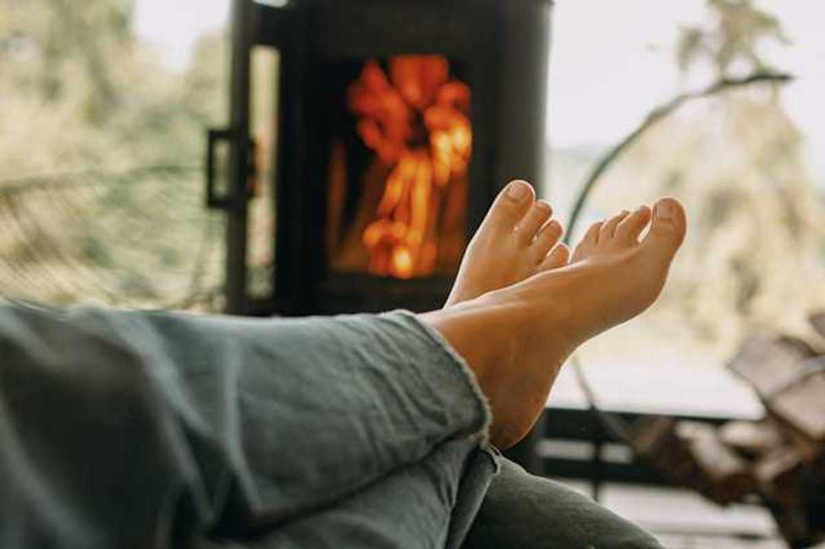 A person sitting in front of a woodstove