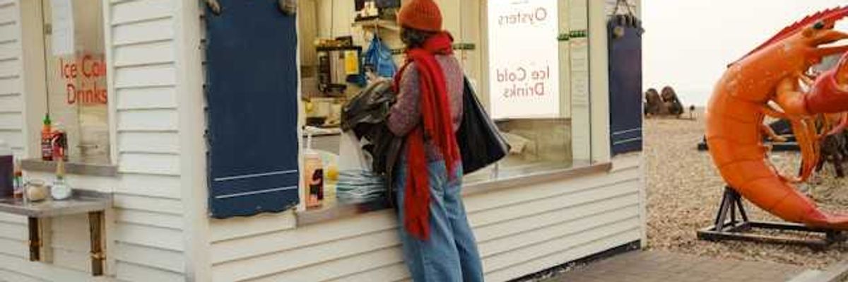 A person standing at an outdoor kiosk which sells oysters