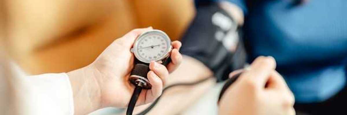 A person taking a patient's blood pressure