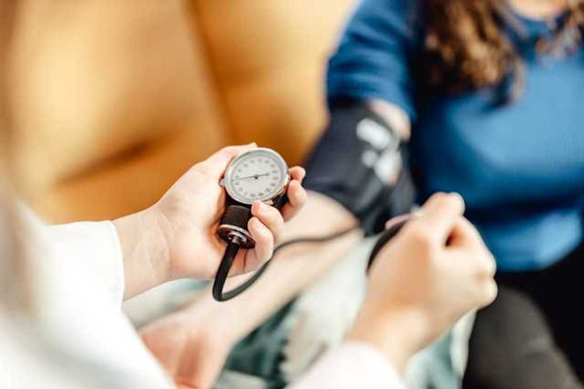 A person taking a patient's blood pressure