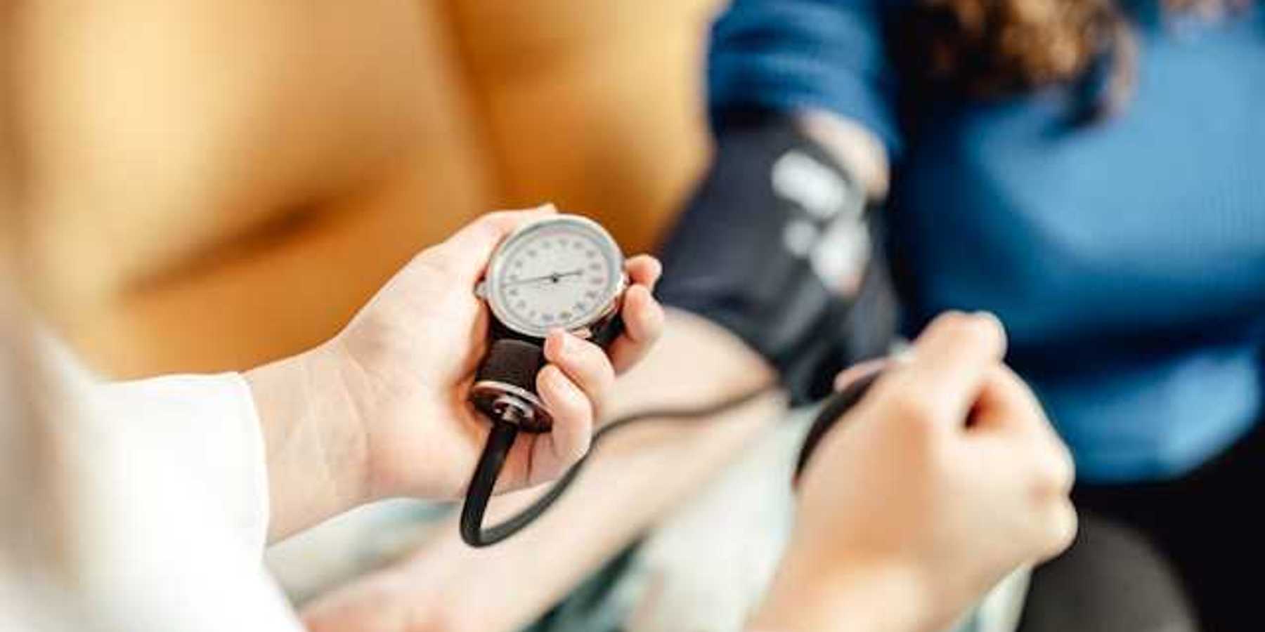 A person taking a patient's blood pressure