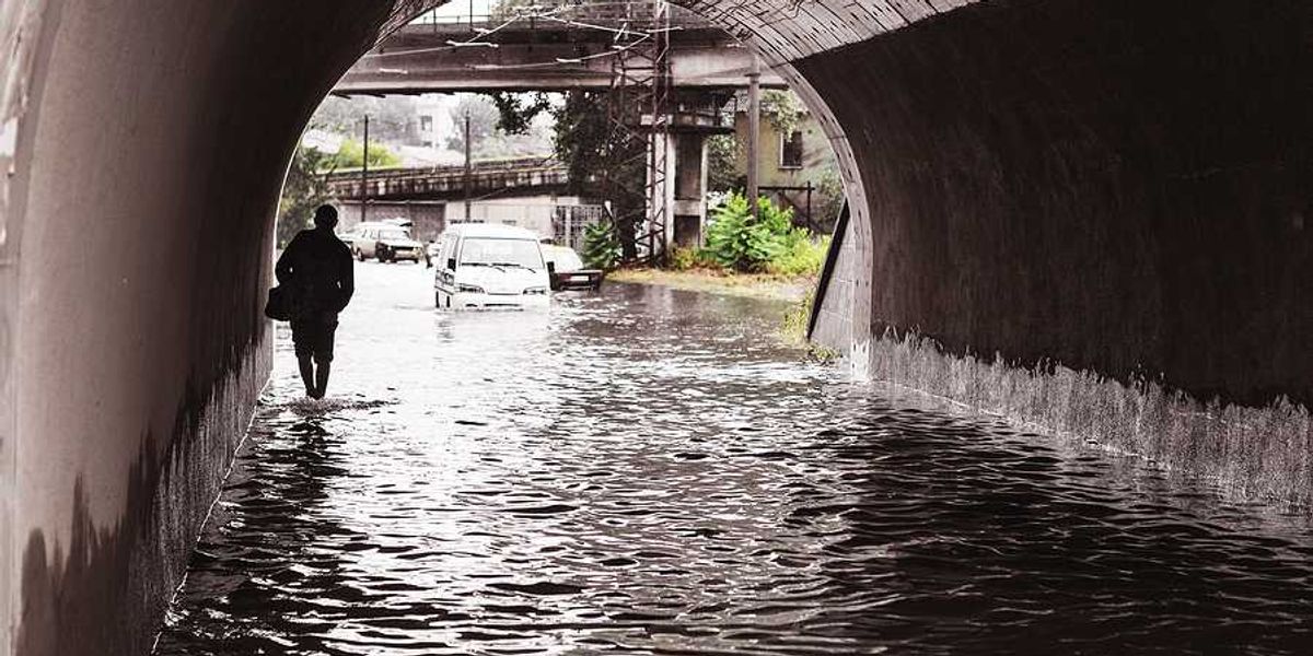 A person walking through a flooded underpass