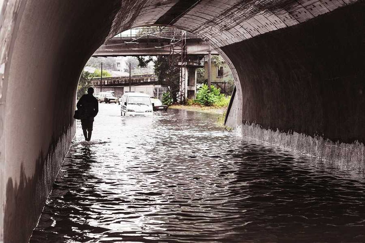A person walking through a flooded underpass