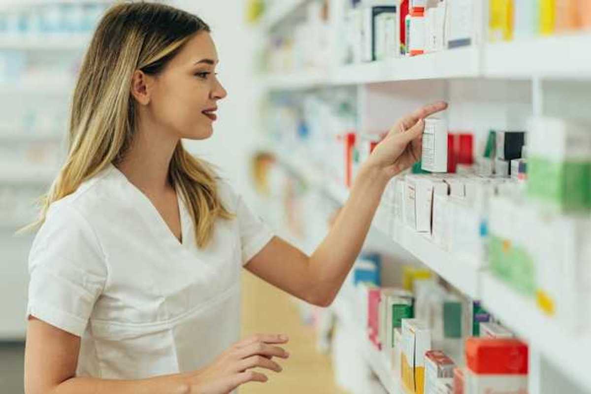 A pharmacist looking at products on a shelf